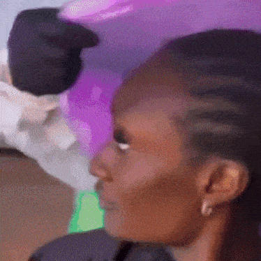 a close up of a woman 's face with a purple balloon in the background