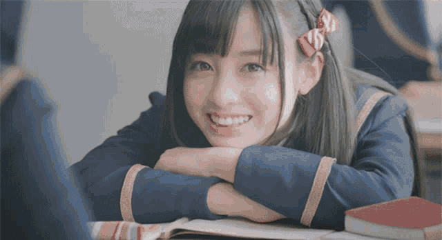 a girl with a red bow in her hair is smiling