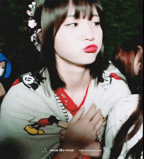 a girl wearing a mickey mouse shirt making a face