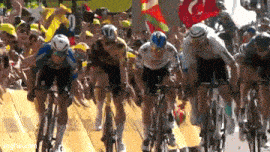 a group of cyclists are racing down a road with a crowd behind them and the number 10 on their jersey