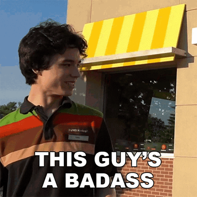 a man in a burger king uniform says " this guy 's a badass " in front of a yellow awning