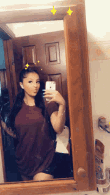 a woman is taking a picture of herself in a mirror