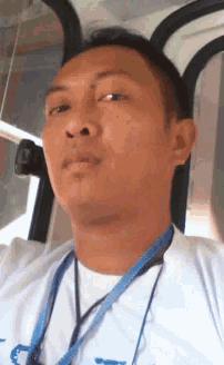 a man wearing a white shirt and a blue lanyard with the letter a on it