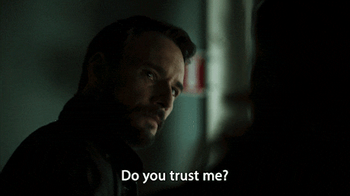 a man with a beard is talking to another man and says " do you trust me "