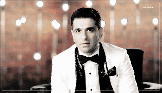 a black and white photo of a man in a tuxedo with opsora written in the corner