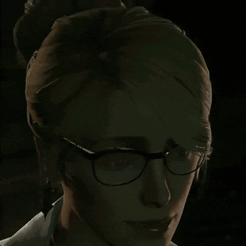 a close up of a woman 's face with glasses