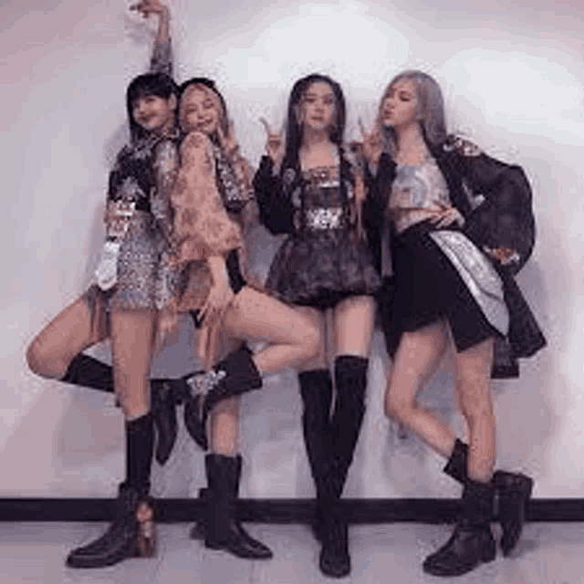 a group of four women are posing for a picture together .