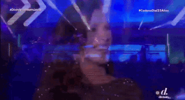 a blurry picture of a woman on a stage with the words divinity comamusica in the corner