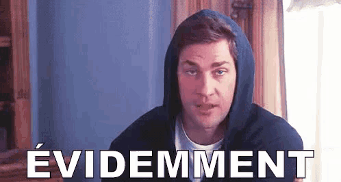 a man in a hooded sweatshirt is looking at the camera with the word evidement written in front of him .