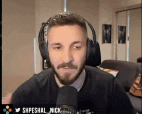 a man with a beard is wearing headphones and talking into a microphone