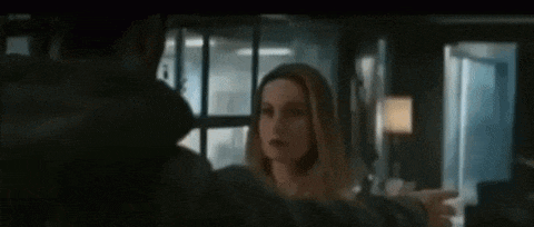 a man and a woman are standing next to each other in a living room .