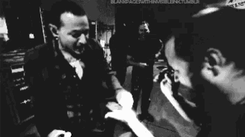 a black and white photo of a person holding a man 's hand .
