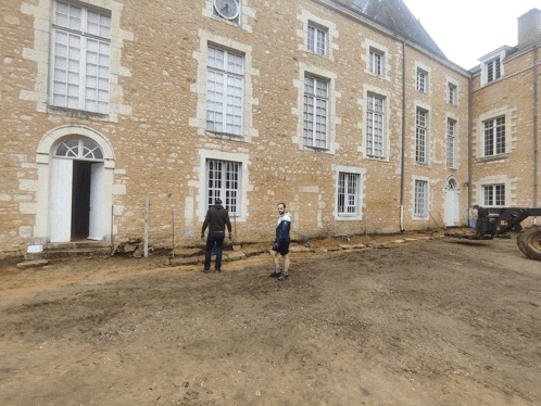 two men standing in front of a large building