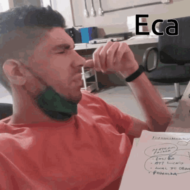 a man wearing a mask is sitting at a desk with eca written on the top