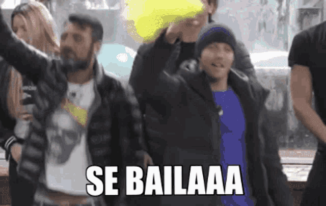 a group of people are dancing with the words se bailaaa written on the screen