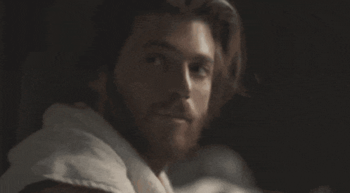 a close up of a man with a beard wearing a robe .