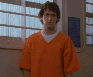 a man in an orange prison uniform is giving the peace sign