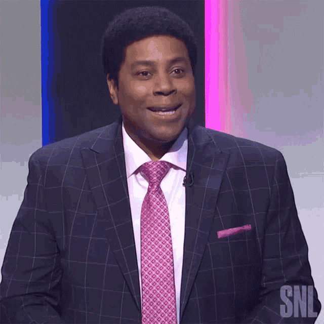 a man in a suit and tie with the snl logo