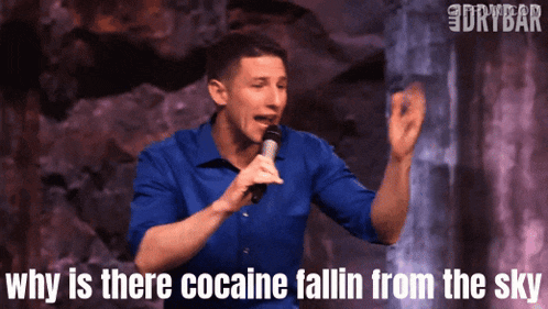 a man singing into a microphone with the words " why is there cocaine fallin from the sky " above him