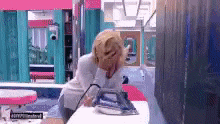 a woman is ironing a piece of clothing on a table in a room .