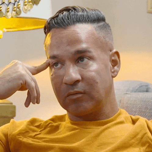 a man in a yellow shirt has his hand to his forehead