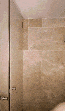 a bathroom with a tiled wall and a shower stall