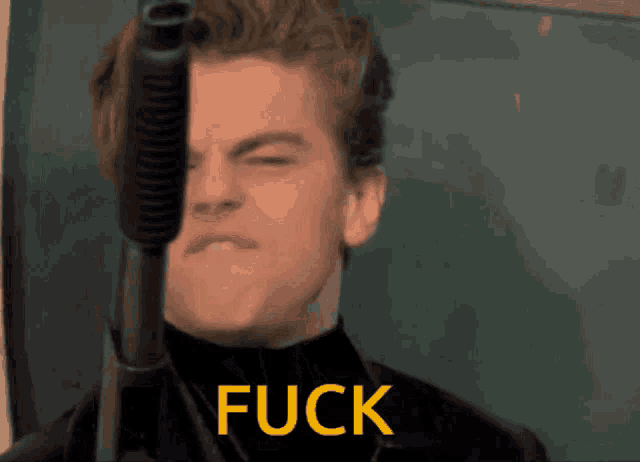 a man is holding a gun in front of his face and the word fuck is below him