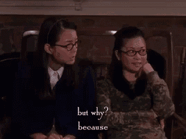 two women wearing glasses are sitting next to each other on a couch and one of them is asking the other why .