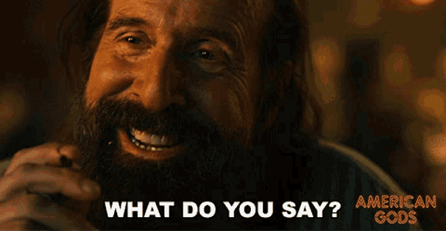 a man with a beard is smiling with the words what do you say below him
