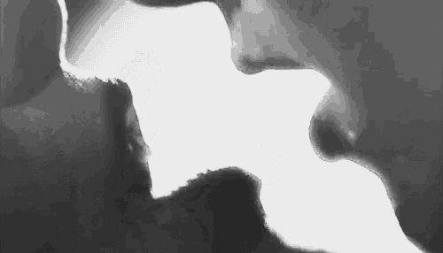 it is a black and white photo of a man and woman kissing .