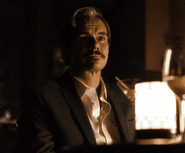 a man with a mustache wearing a suit and white shirt