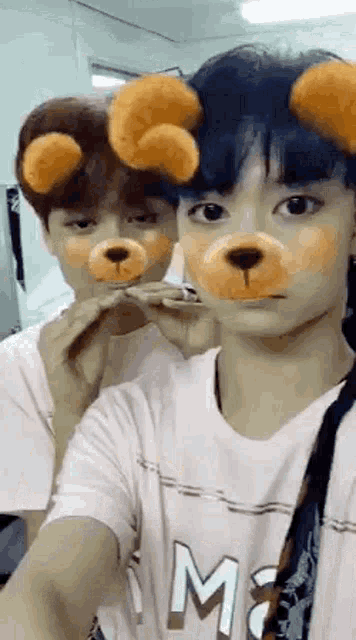 two young men wearing teddy bear face masks are taking a selfie .