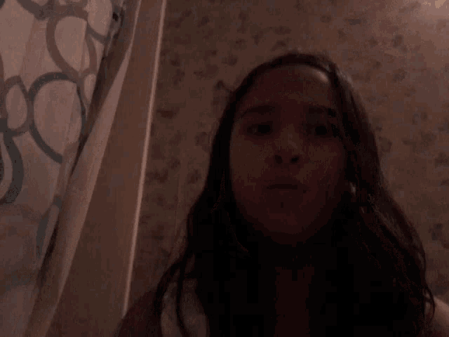 a girl in a dark room with a shower curtain