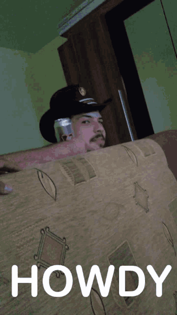 a man in a cowboy hat is holding a can of coca cola in his hand
