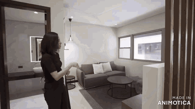 a woman is standing in a living room with a couch and tables made in animotica