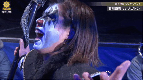 a woman with blue paint on her face holds a stick