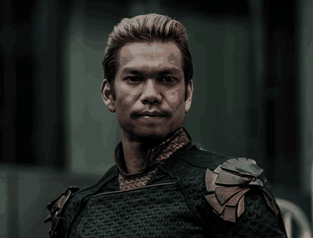 a man with a mustache is wearing a black armor