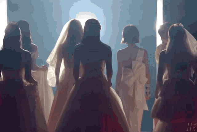 a group of women in white dresses are standing in a line