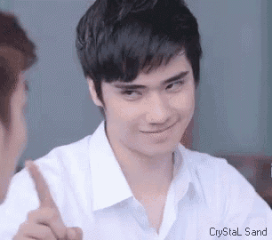 a young man in a white shirt is making a funny face while pointing up .