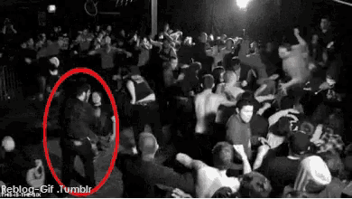 a black and white photo of a crowd with a red circle around a man in the middle .