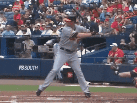 a baseball player is swinging at a ball in front of a fs south sign
