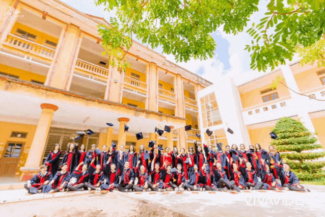 a group of graduates throw their caps in the air in front of a building that says vivid