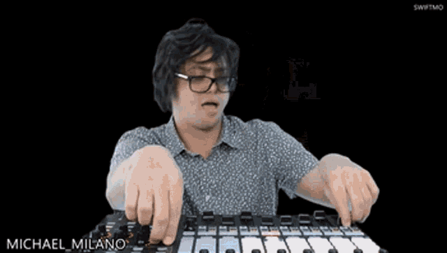 a man playing a keyboard with the name michael milano written on the bottom