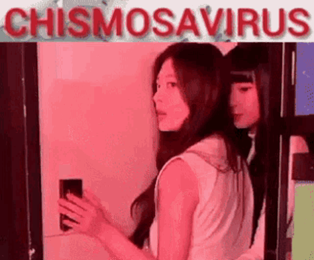two women are standing next to each other in a room with the words chismosavirus written on the bottom .