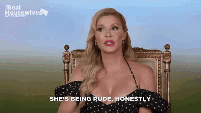 a woman is sitting in a chair with the words she 's being rude honestly behind her