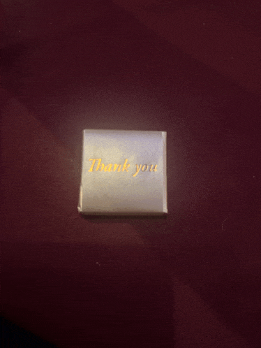 a small thank you card is sitting on a table