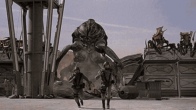 a man and a woman are walking in front of a monster .