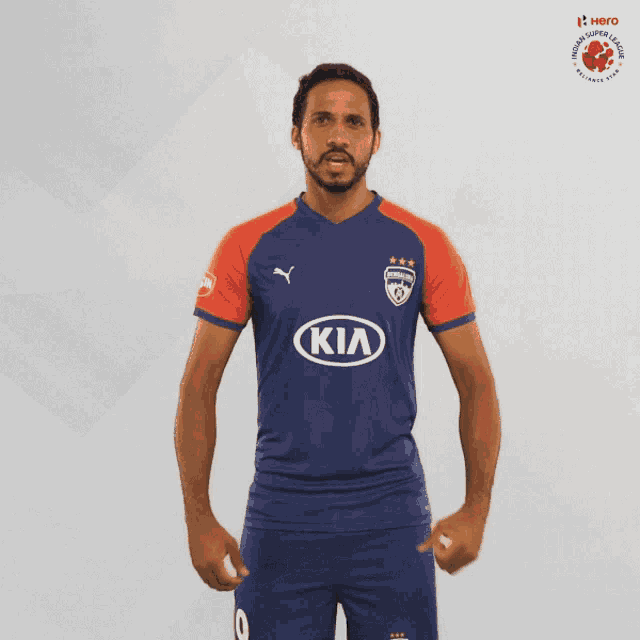 a soccer player wearing a blue and red kia jersey