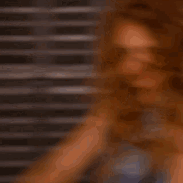 a woman with long red hair is wearing a blue shirt