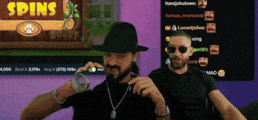 two men sitting in front of a screen that says spins on it